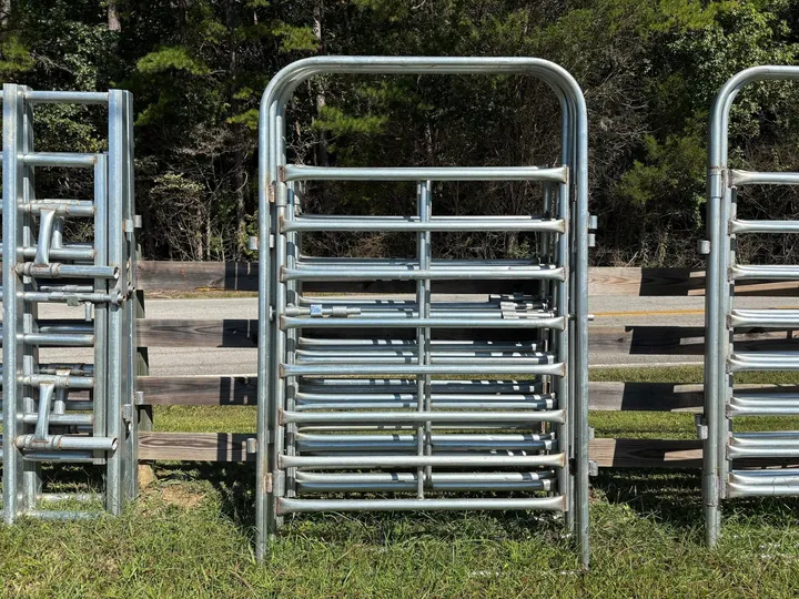 Galvanized 5-foot heavy bow gate standing between other gates
