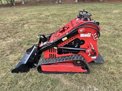 Red SSL60 mini skid steer with bucket, side view in a field