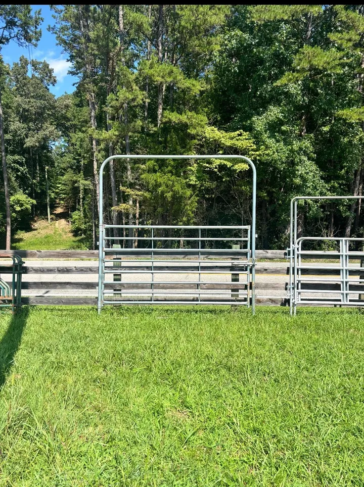 Galvanized 10-foot heavy high-top bow gate standing in a pasture