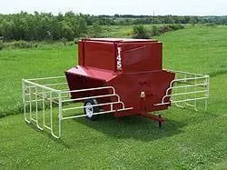 Red 145 bushel creep feeder with panels in a pasture