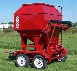 Red 3 ton portable bulk bin with solar powered auger on a tandem axle trailer