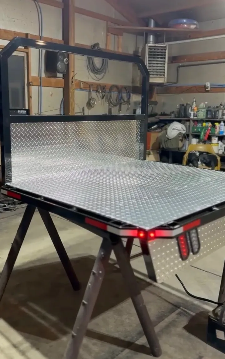 Aluminum flat bed with headache rack on sawhorses before installation