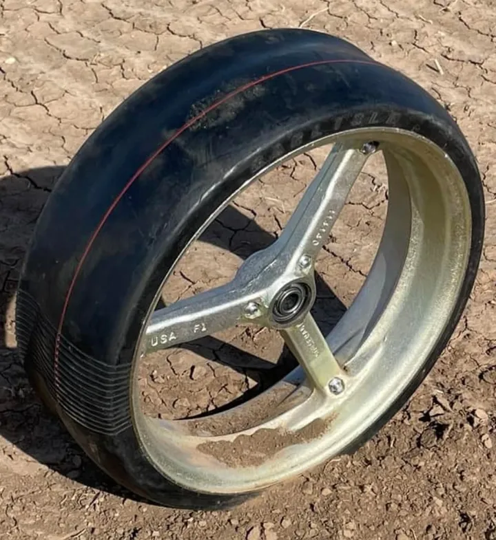 Norseman open spoke gauge wheel resting on bare soil