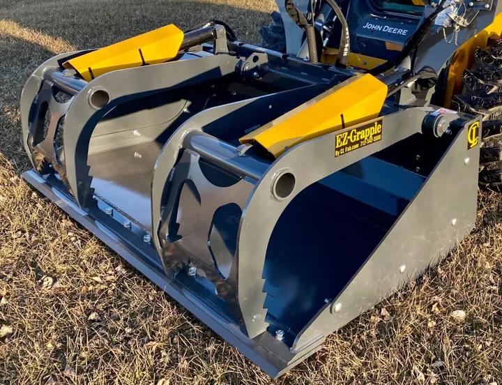 Solid bucket with dual grapples, angled view in grass