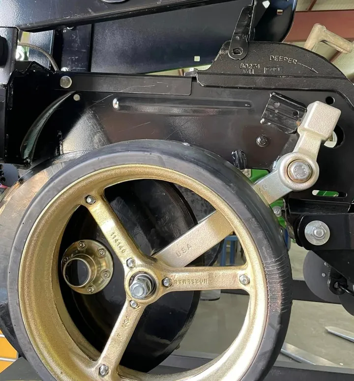Norseman gauge wheel arm and open spoke gauge wheel installed on a planter row unit