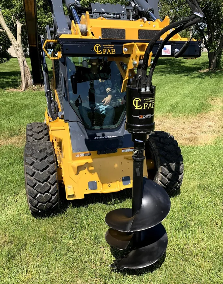 Skid steer with auger drive attached, front view