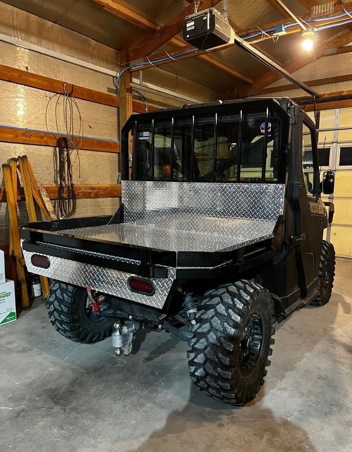 Side by side with aluminum flat bed in a shop