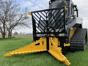 CL Fabrication tree puller on a compact track loader in a field